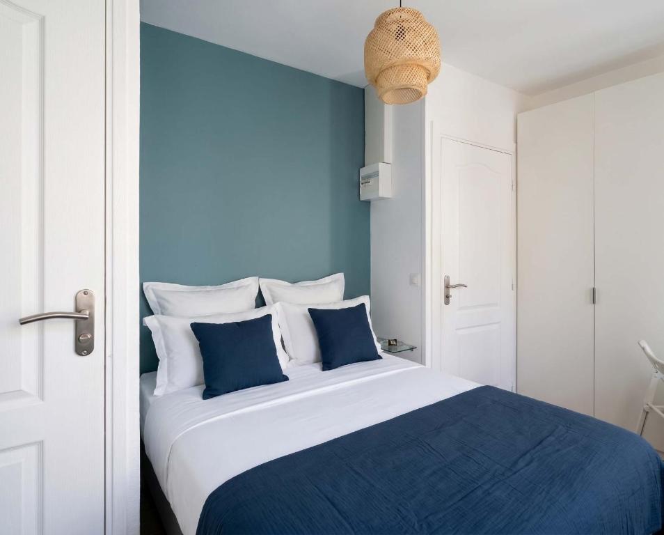 a blue and white bedroom with a large bed at Hôtel My Suite Paris in Paris