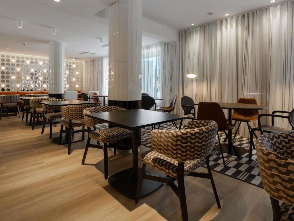 a restaurant with tables and chairs in a room at ibis Styles Tallinn in Tallinn