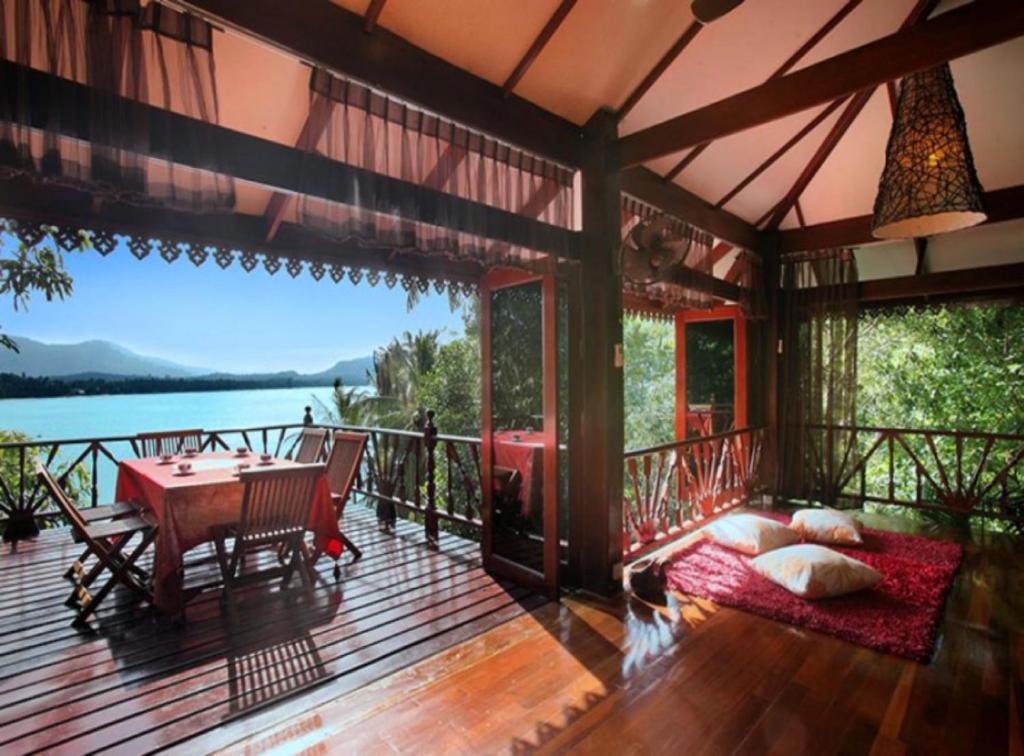 スリタヌにある7 Bedroom Seafront Villa Phanghan SDV232-By Samui Dream Villasの水辺の景色を望むポーチ(テーブル付)