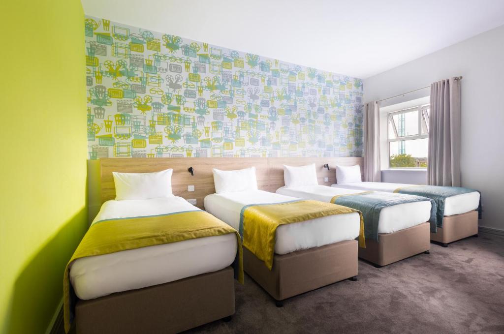 two beds in a room with green walls at The Camden Street Hotel in Dublin