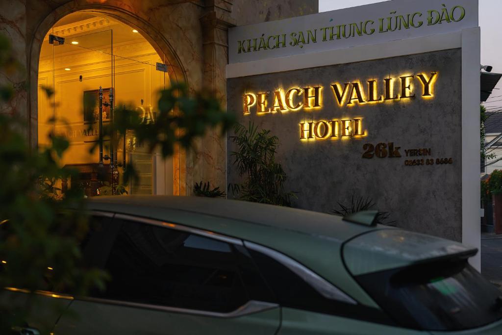 a car parked in front of a plant valley hotel at Peach Valley Hotel Dalat in Da Lat