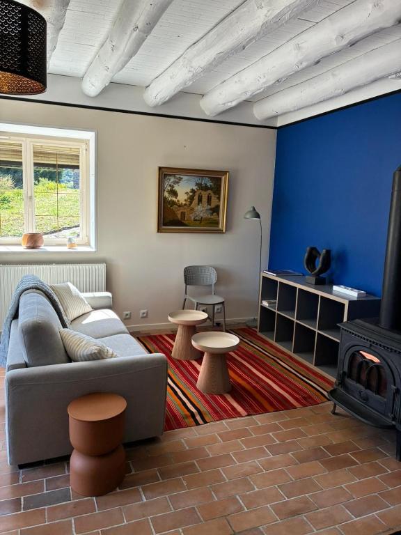 a living room with a couch and a fire place at Chez Albert, in Saint-Ilpize