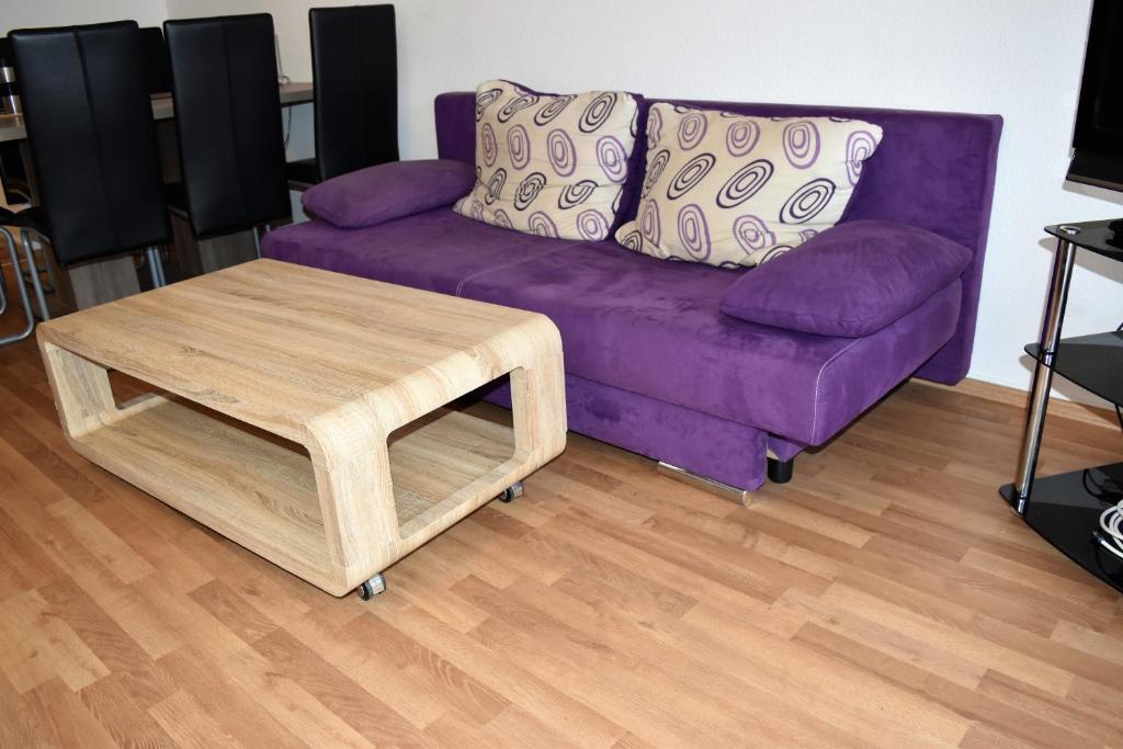 ノイスにあるWork & stay Neussの紫色のソファ、リビングルーム(コーヒーテーブル付)
