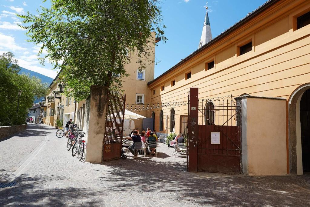 um grupo de pessoas sentadas fora de um edifício em Alter Schlachthof em Bressanone