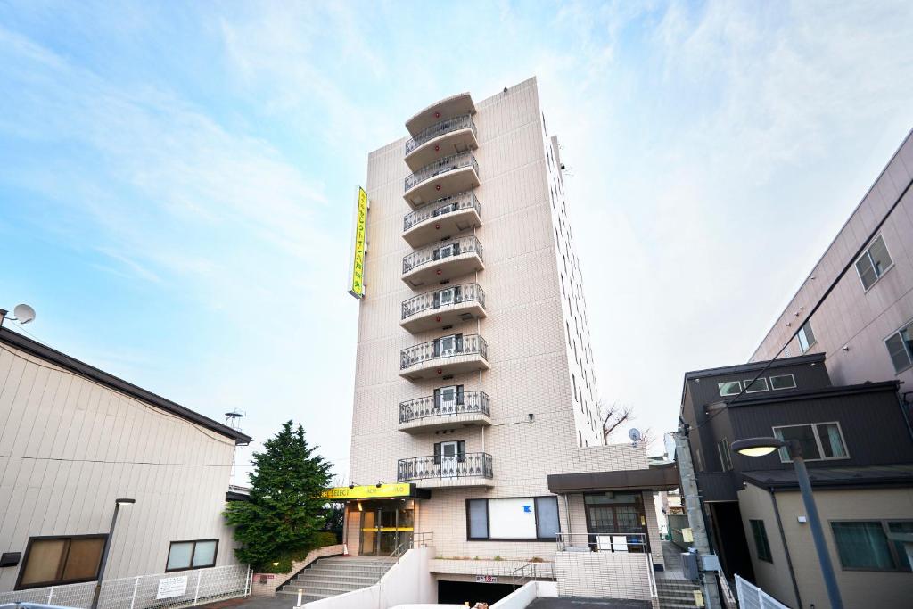 un edificio alto y blanco con balcones. en Hotel Select Inn Hachinohe Chuo en Hachinohe