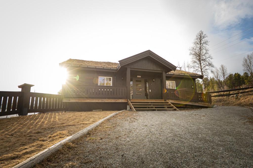 a small house with the sun in the background at Karstenstua in Holo