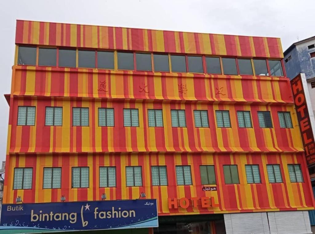 a large orange building with a red and yellow facade at One World Lodging in Bentong