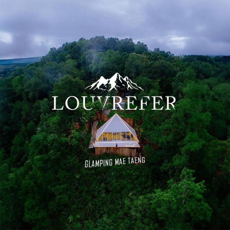 a building in the middle of a forest with a mountain at LOUVREFER in Ban Pa Pae