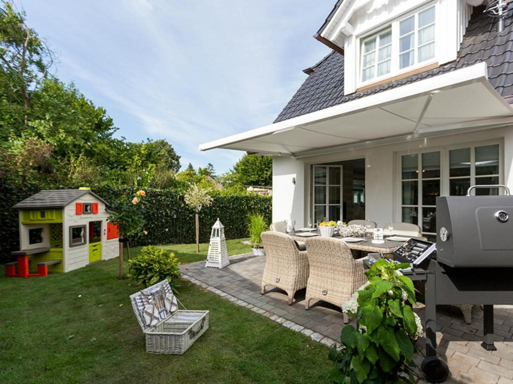 a backyard with a grill and a table and chairs at Ferienhäuser Zingster Perlen in Zingst