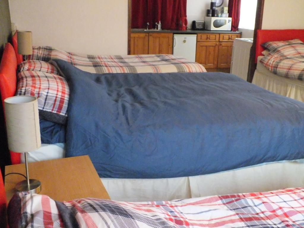 a bedroom with a blue bed and a table at Bonna's Bed And Breakfast in Builth Wells