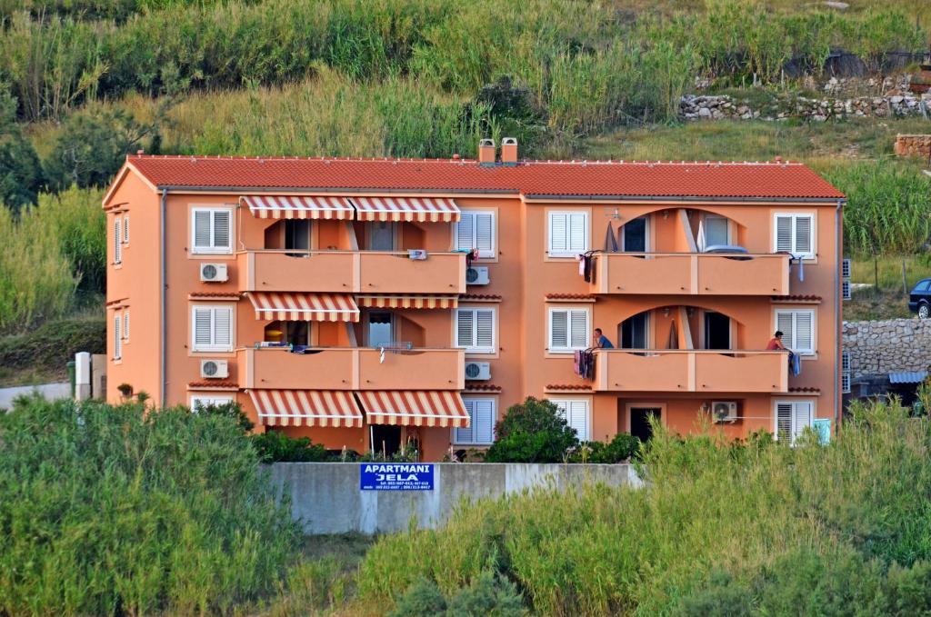 an orange building on the side of a hill at Apartments Jela in Metajna