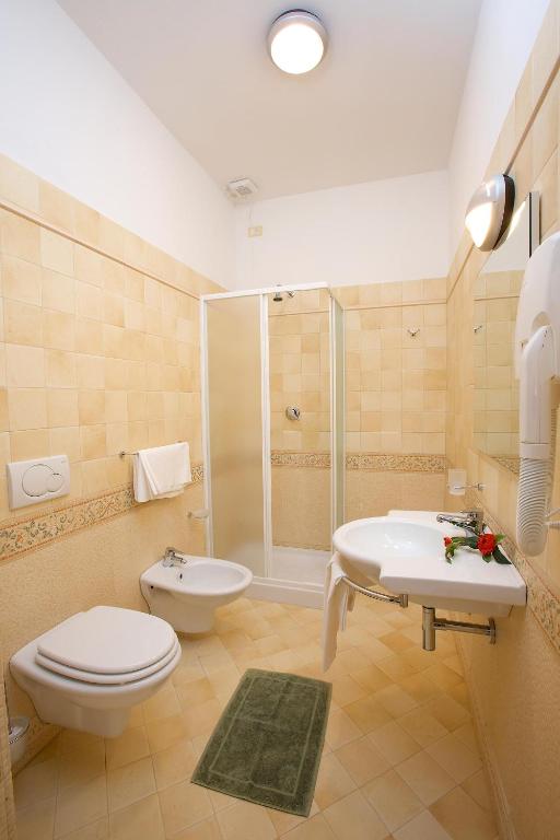 W łazience znajduje się toaleta, umywalka i prysznic. w obiekcie Hotel Da Angelo w Asyżu
