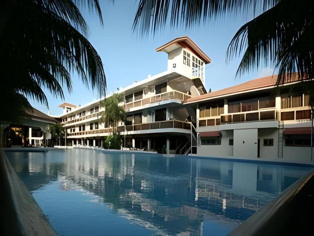 a hotel with a swimming pool in front of a building at Splash Oasis Resort & Hotel in Forestry