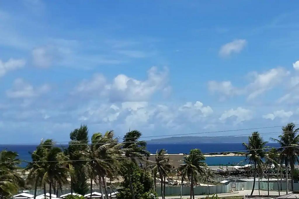 a view of a beach with palm trees and the ocean at Tinian diamond hotel in Tinian International Airport