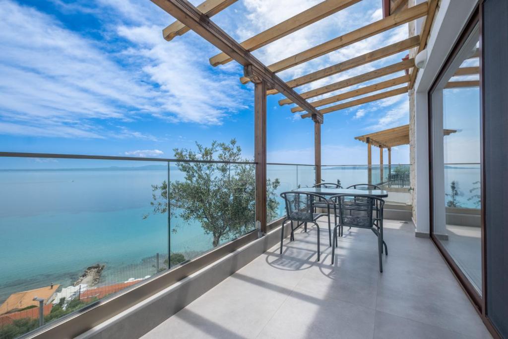 a dining room with a view of the ocean at Grande Blu by NG Villas in Afitos
