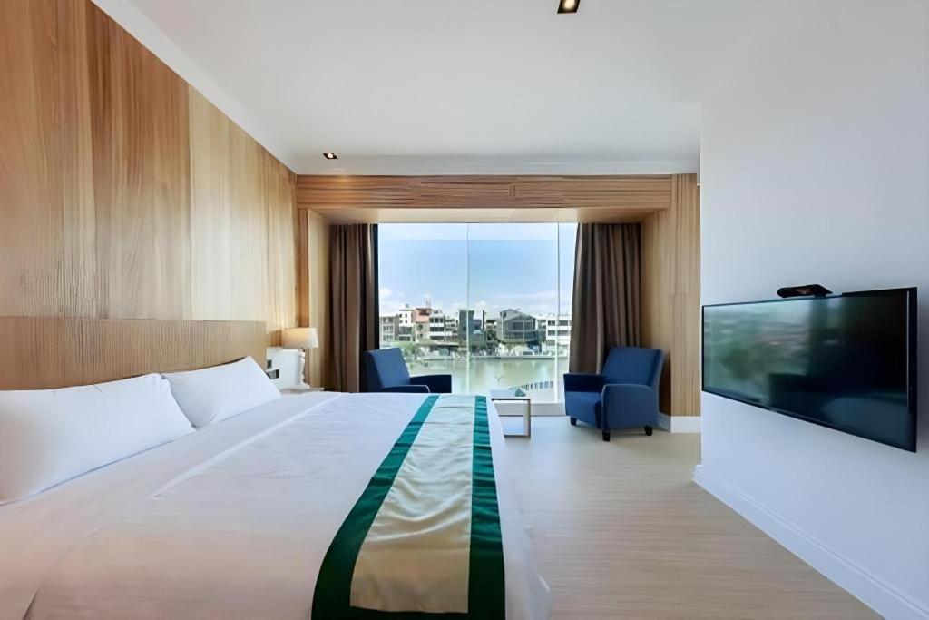 a hotel room with a large bed and a flat screen tv at Read River in Anping