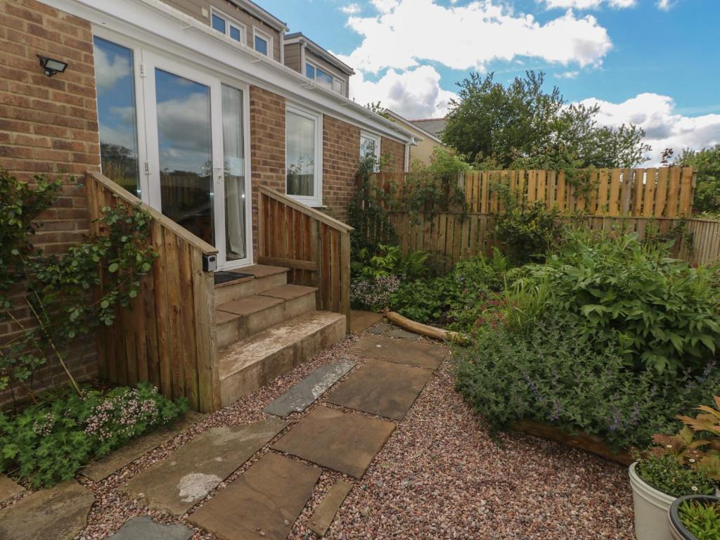 a garden with a house with a wooden stairway at Garden View in Pembroke
