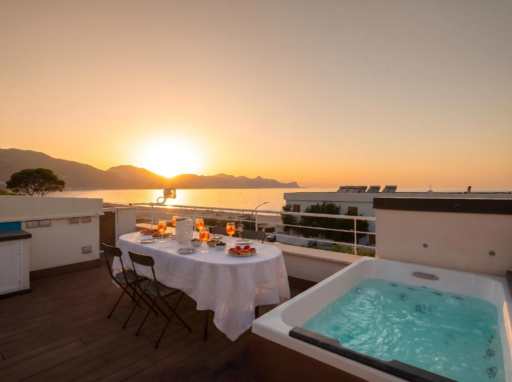 a balcony with a table and a bath tub at CasaSol Deluxe villa sulla Spiaggia con Piscina e Jacuzzi By Sicily Home Solutions in Alcamo