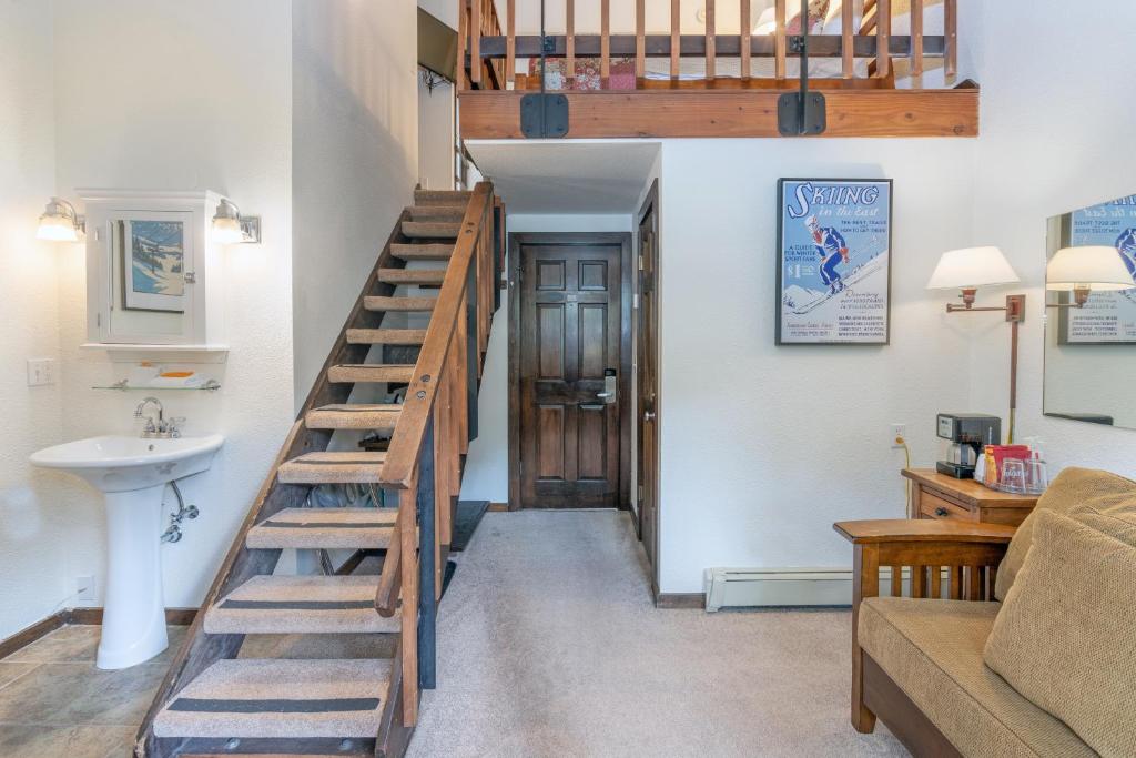 a living room with a stairs leading up to a loft at Manitou Lodge 8 by Alpine Lodging Telluride in Telluride