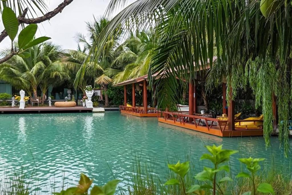 a swimming pool with green water and palm trees at S Garden View Resort in Ban Bang Yai Chuai
