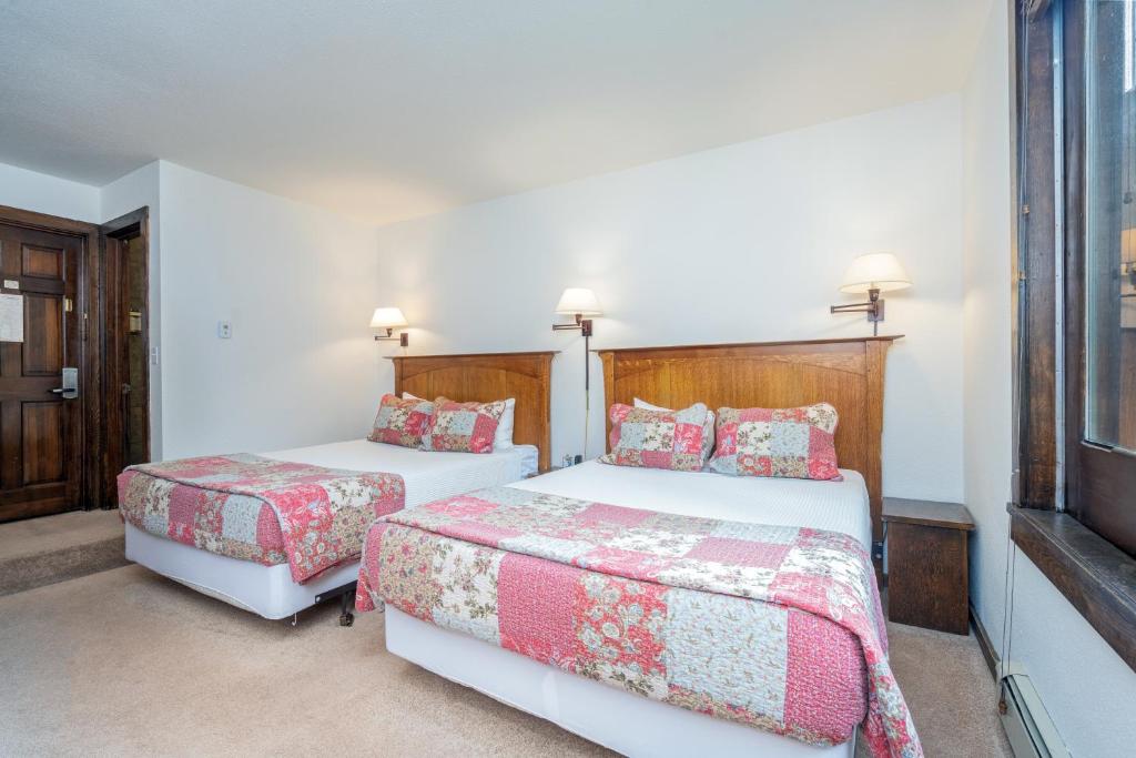 a bedroom with two beds and a window at Manitou Lodge 2 by Alpine Lodging Telluride in Telluride