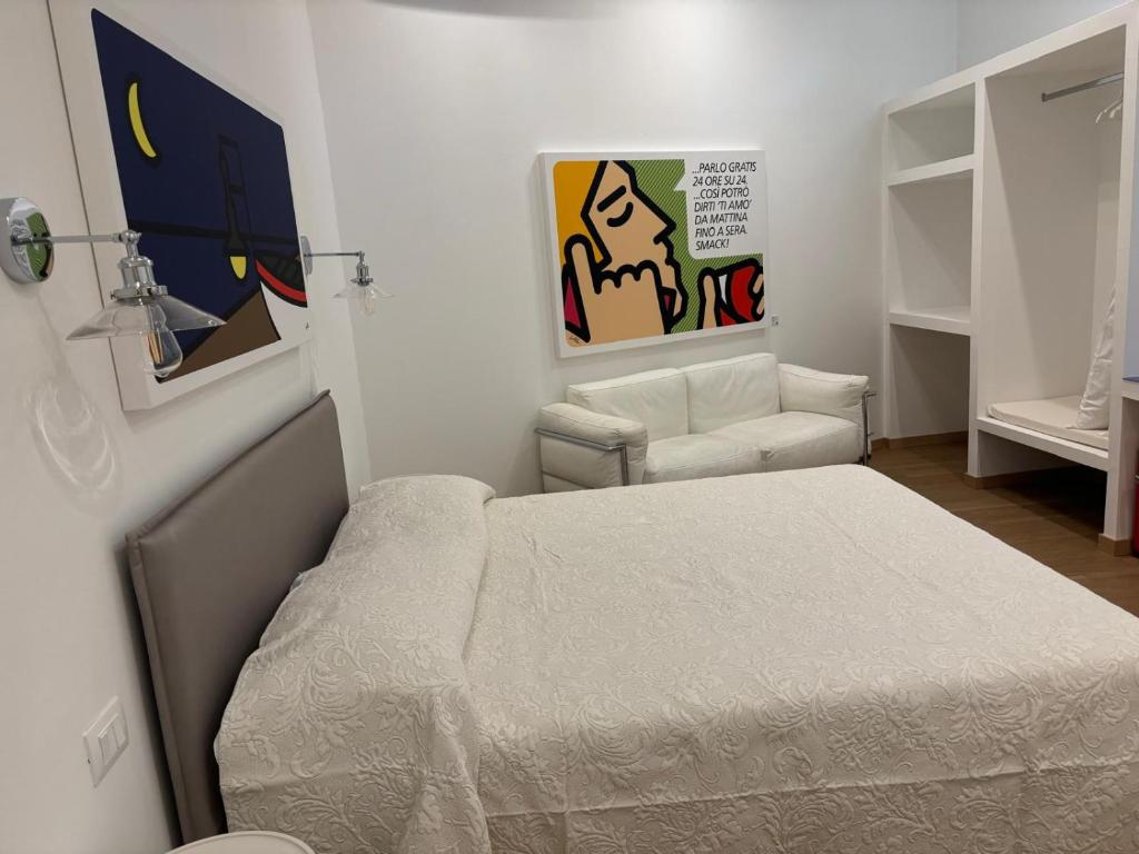 a small bedroom with a bed and a chair at Corsica Rooms in Termoli