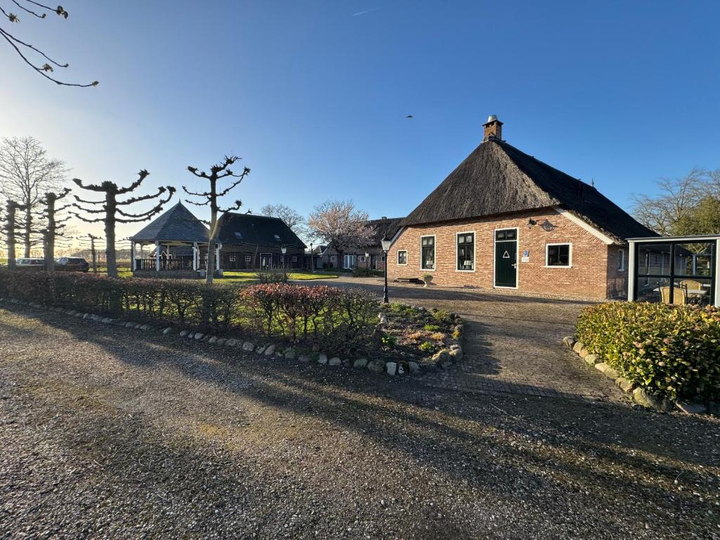 a large brick building with a grass roof at Hotel Ter Linde in Zuidwolde