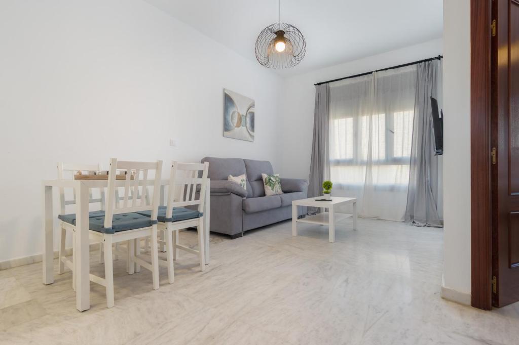 a living room with a couch and a table at Lux Sevilla Apartment Piscina in Bormujos