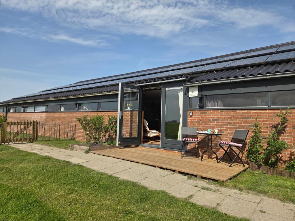 a brick house with a deck and a table at Molesicht en Lânsicht in Workum
