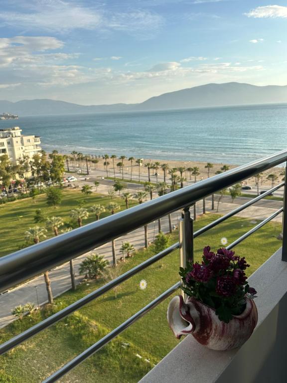 a vase of flowers sitting on a balcony overlooking the beach at Lungomare ViewPoint in Vlorë