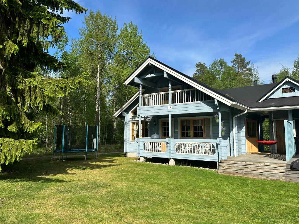 a white house with a porch and a yard at Kultaloma Slalom in Kuopio