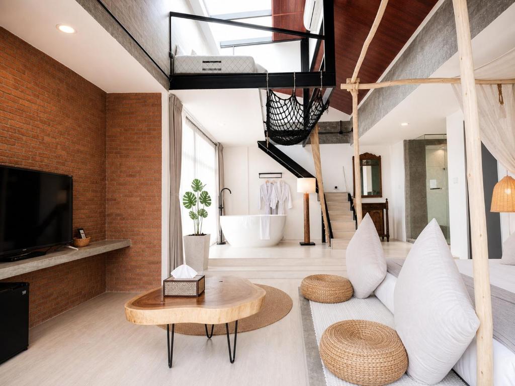 a living room with a couch and a tv at YOLO Bangkok Boutique Hotel in Bangkok