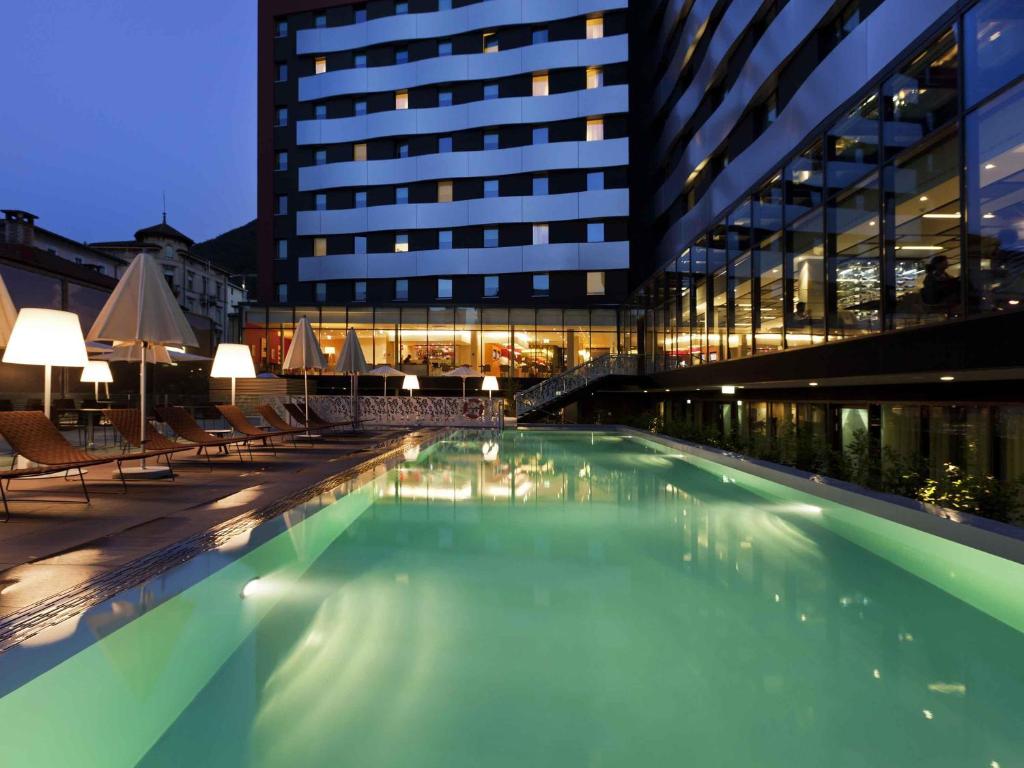 a large swimming pool in front of a building at Novotel Lugano Paradiso in Lugano
