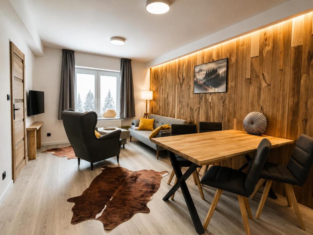 a living room with a table and chairs and a couch at Apartmány Panorama Harrachov in Harrachov