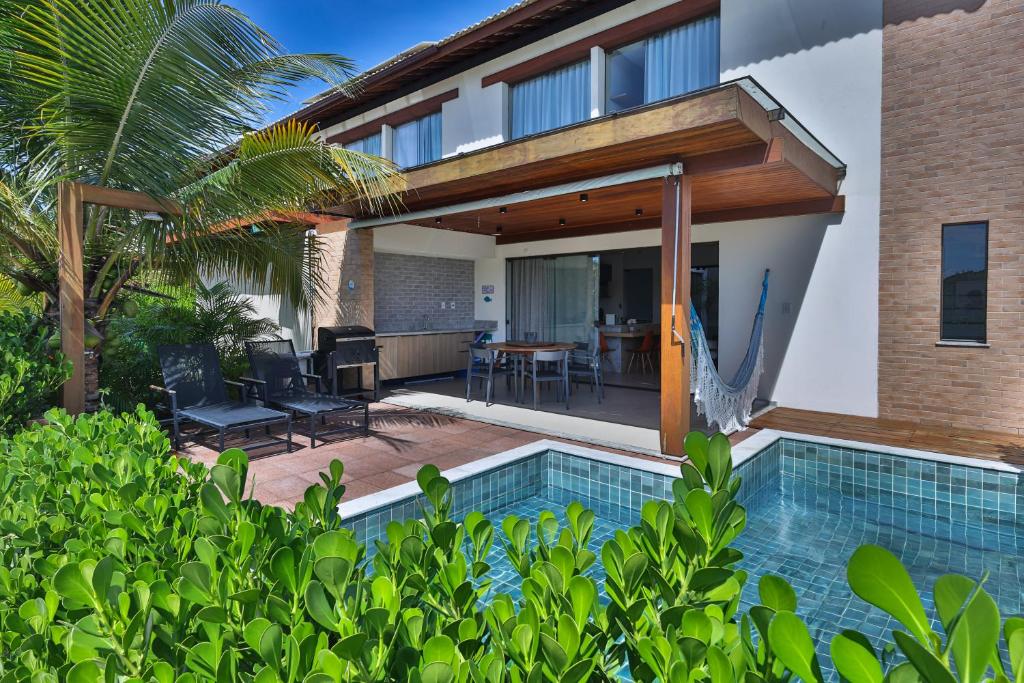 an external view of a house with a swimming pool at Condominio Frente Mar 3 suites com Ar Cond piscina e Hidro privativa in Mata de Sao Joao