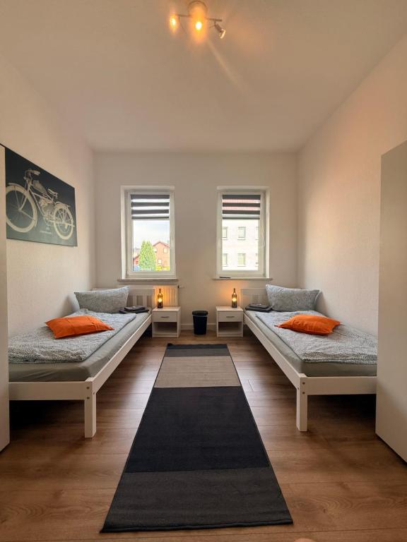 a room with two beds and two windows at Stay&Work Döbeln - Hermsdorfer Straße in Döbeln