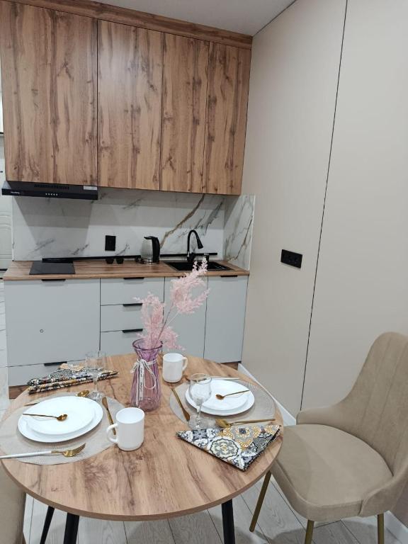 a table with plates and cups on it in a kitchen at ЖК Akjol in Astana