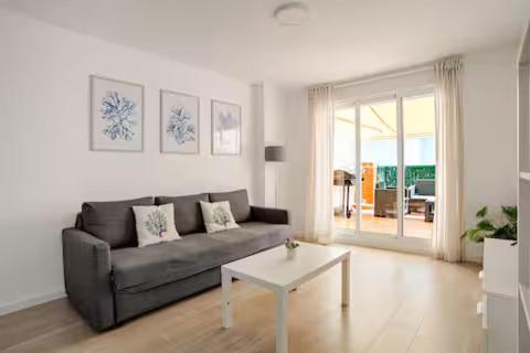 a living room with a couch and a table at Ático puerto Burriana in Burriana
