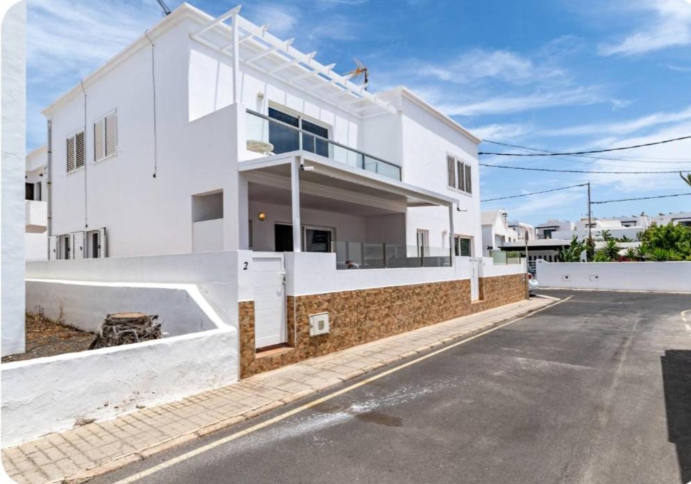 a white house with a street in front of it at Barlovento Apartment 2 in Playa Honda