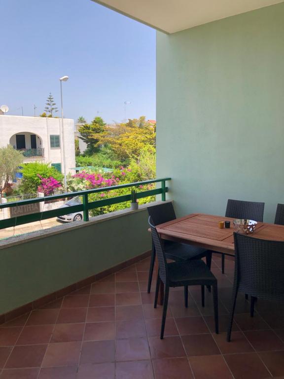a dining room with a table and chairs and a balcony at Oasi Baia Verde in Baia Verde