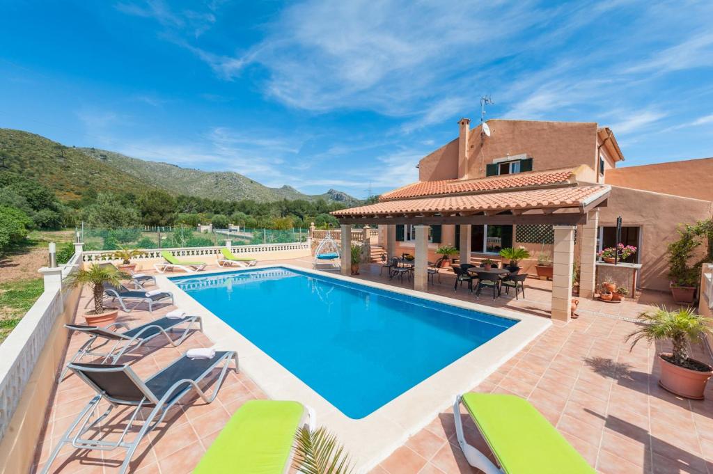 a villa with a swimming pool and patio furniture at Villa Bona Vista in Capdepera