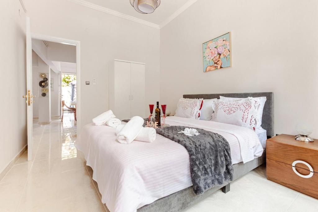 a white bedroom with two beds with white sheets at Enora Loutraki Guesthouse in Loutraki
