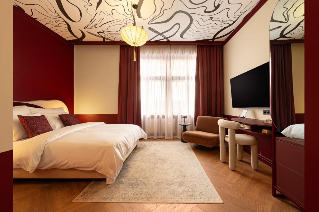 a hotel room with a bed and a desk and a tv at TWENTYSEVEN Boutique in Budapest