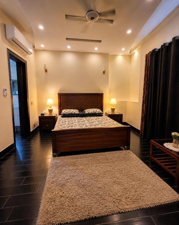 a bedroom with a bed and a ceiling fan at DHA Luxe Stay in Lahore
