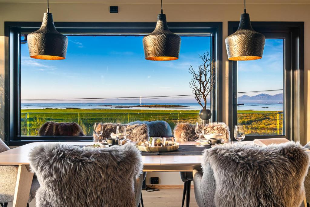 a dining room with a table and a large window at Villa Walter Lofoten with SAUNA in Kvalnes