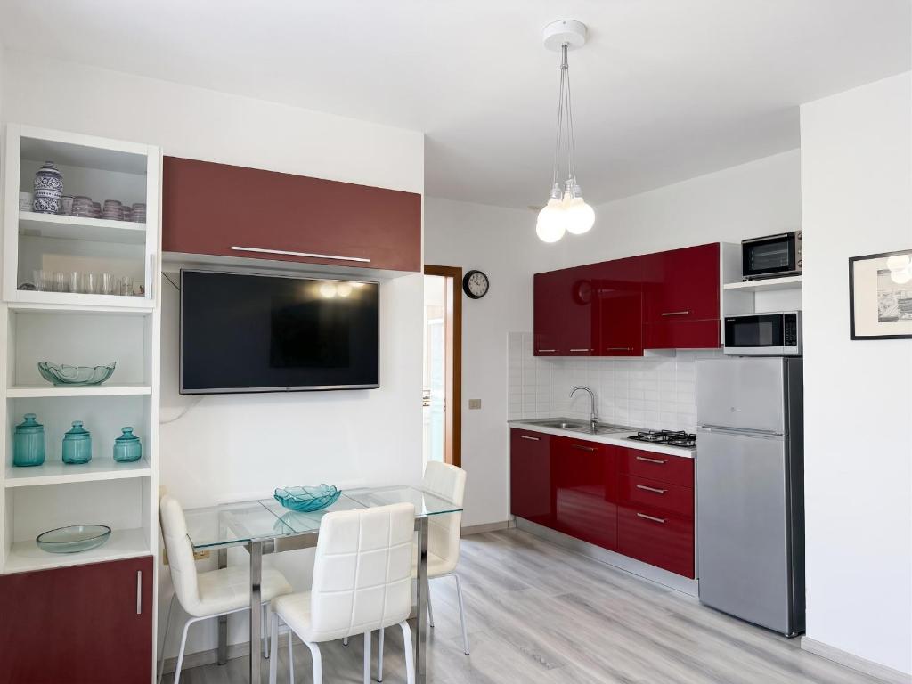 a kitchen with red cabinets and a table with chairs at Piccola Corte in Fano