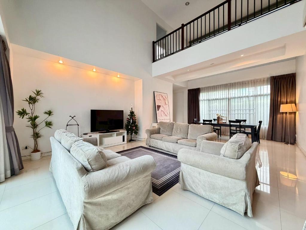 a large living room with couches and a television at Pool Villa Ramkhamhaeng 9 in Bangkok