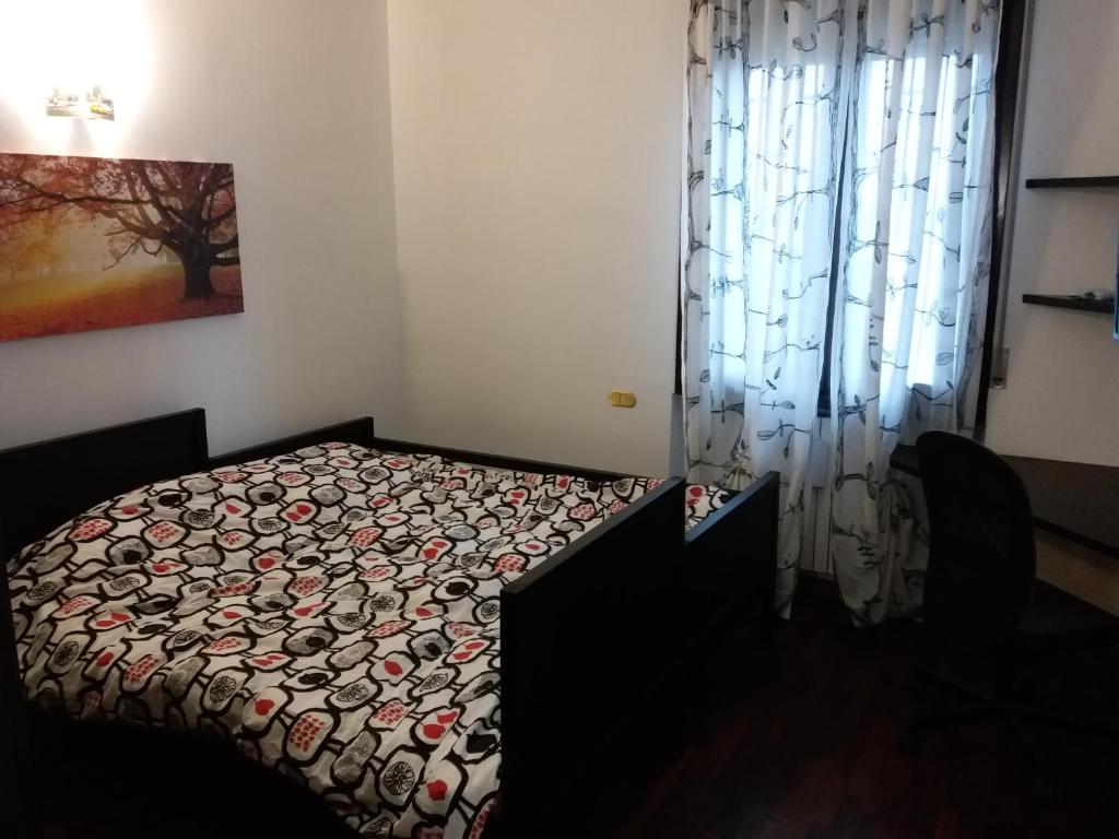 1 dormitorio con cama con edredón y ventana en Villa Tulipani en Rho
