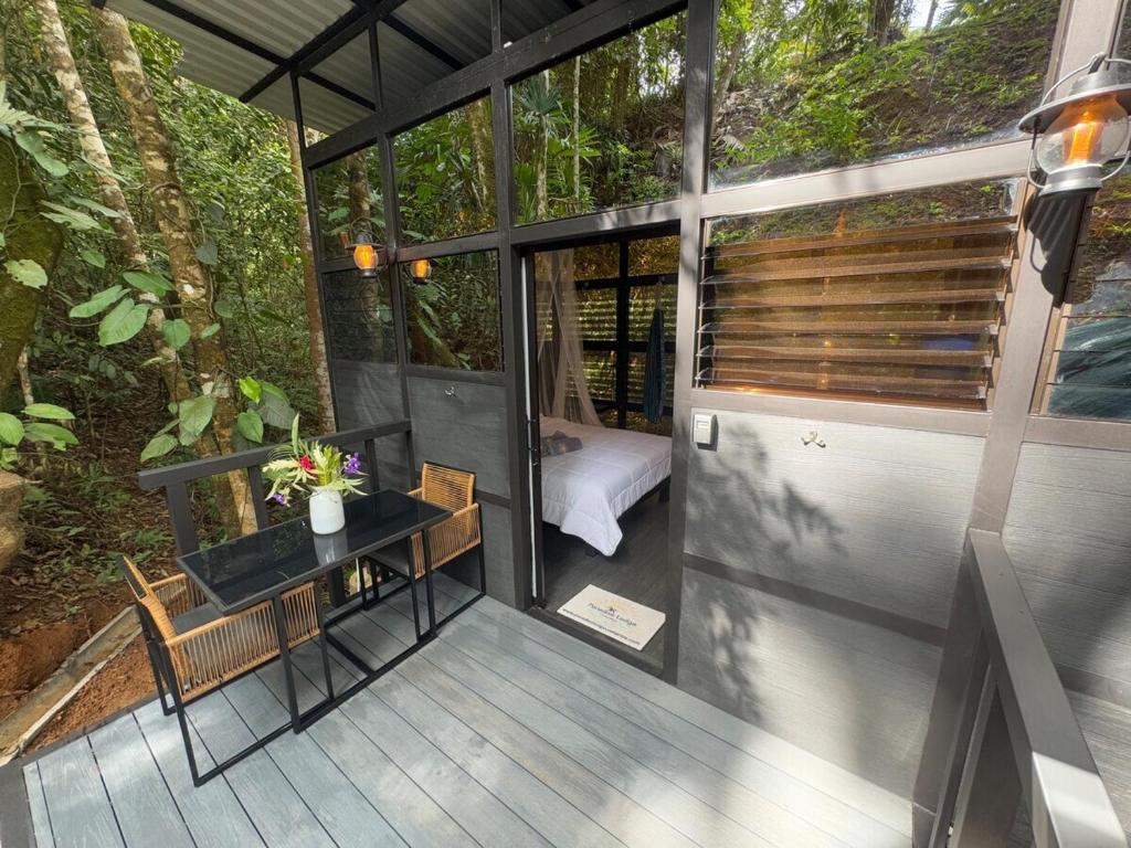 a screened in porch of a house with a table and chairs at Jungle Loft in Platanillo