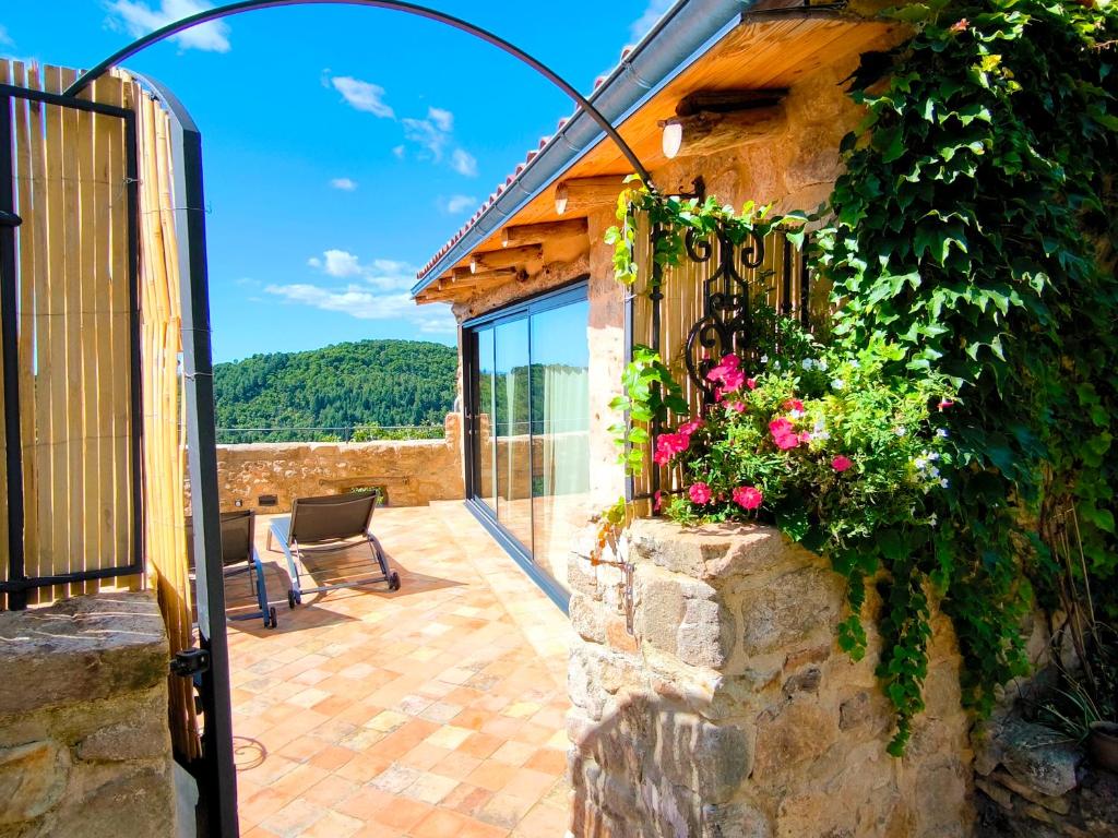 an outdoor patio with flowers on a stone wall at Exklusives Studio inmitten wunderschöner Natur in Lentillères